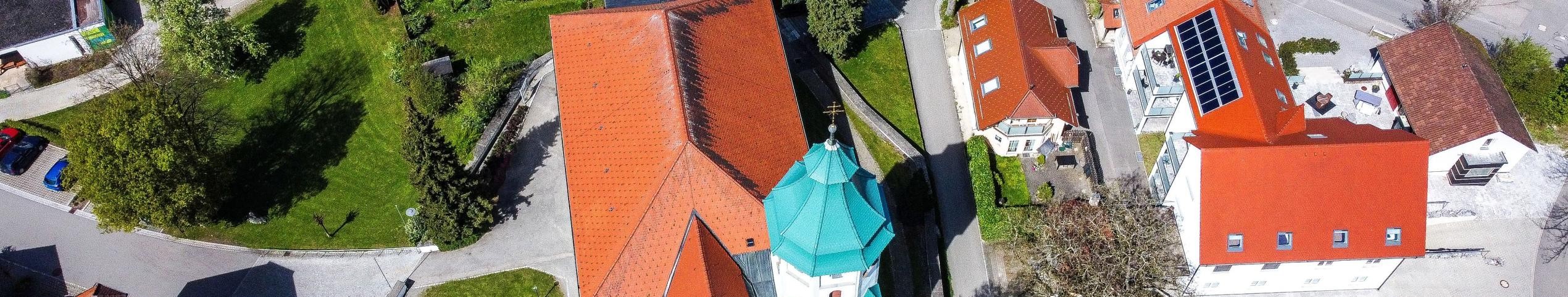 Luftbild mit Mittelpunkt kath. Kirche mit grünem Turmdach